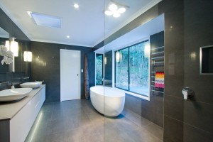 Brisbane Bathroom Company Modern Large Bathroom with ceiling to floor dark porcelain tiles and lass shower screen